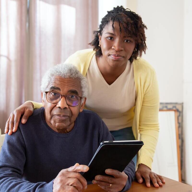 Woman helping a man with using ipad