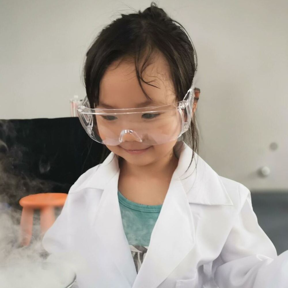 Girl wearing lab glasses and doing chemistry esperiment