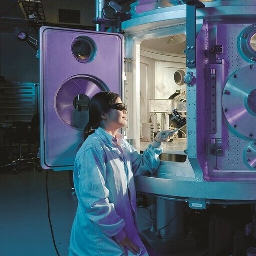 Researcher sitting by advanced research machine